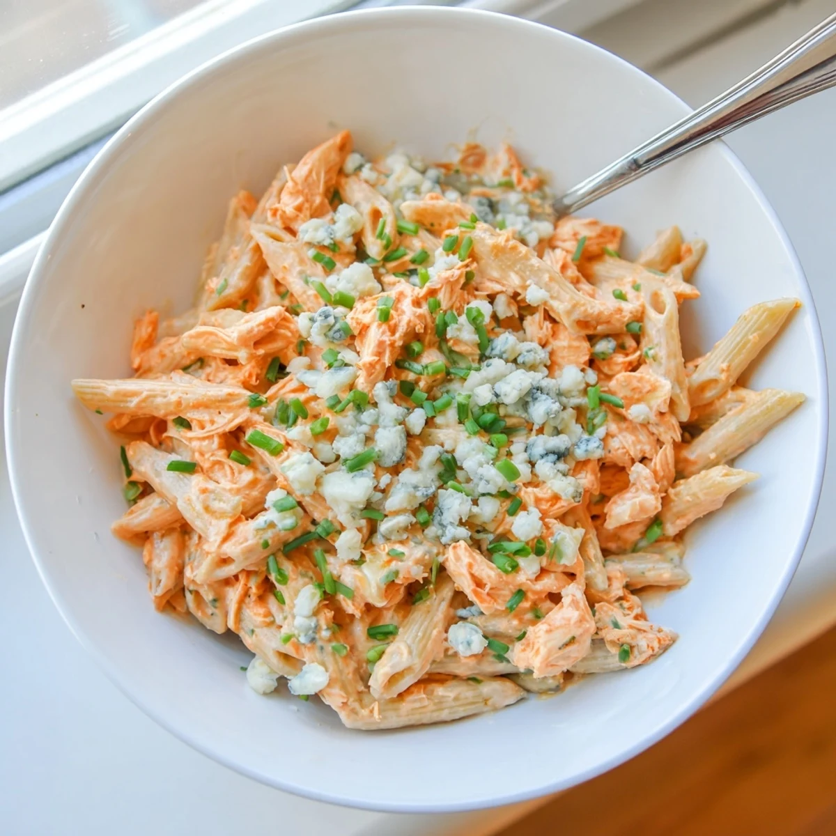 Creamy buffalo chicken pasta with tender shredded chicken tossed in spicy sauce and topped with tangy blue cheese crumbles.