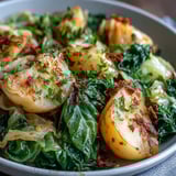 Hearty vegetarian braised cabbage and potatoes with chili steam in a Dutch oven, served with crusty bread alongside.