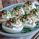 Deviled eggs with tangy cream cheese and zesty everything bagel seasoning, garnished with fresh chives for a flavorful appetizer.