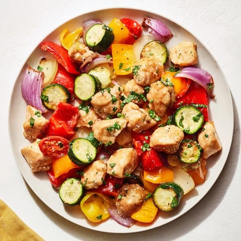 Sheet pan showcasing Basil-Soft Chicken and Veggie Dinner: golden chicken breasts with perfectly cooked, colorful veggies.