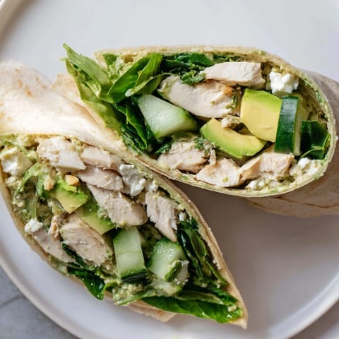 Freshly made Green Goddess Wellness Wrap featuring creamy avocado, ready for a delicious lunch.