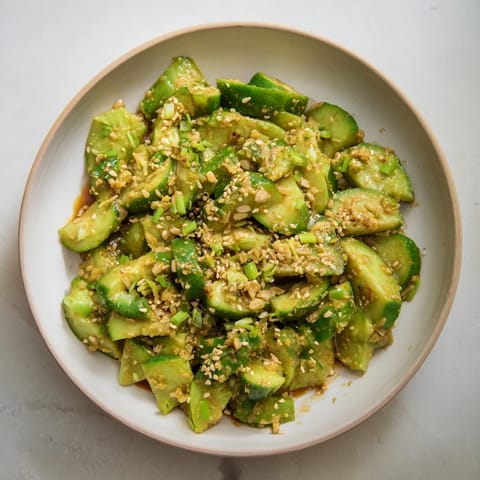 A close-up of a Cucumber Shaker, showing the bright green cucumbers tossed in the umami-rich MSG dressing.