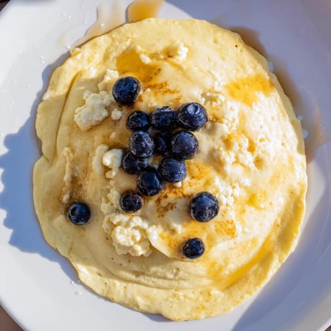 Close-up of freshly cooked scrambled pancakes with blueberries, perfect for an American breakfast.