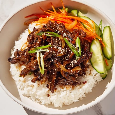 Tender bulgogi beef bowl with glistening marinated beef, colorful veggies, and fluffy white rice.