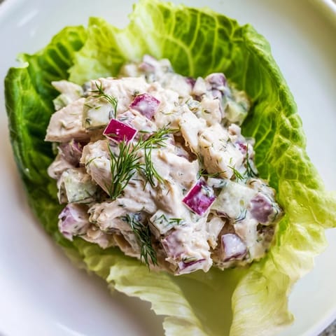 In a Dill Pickle Chicken Salad Lettuce Cup, tangy pickles and creamy dressing top crisp lettuce for a refreshing, light bite.